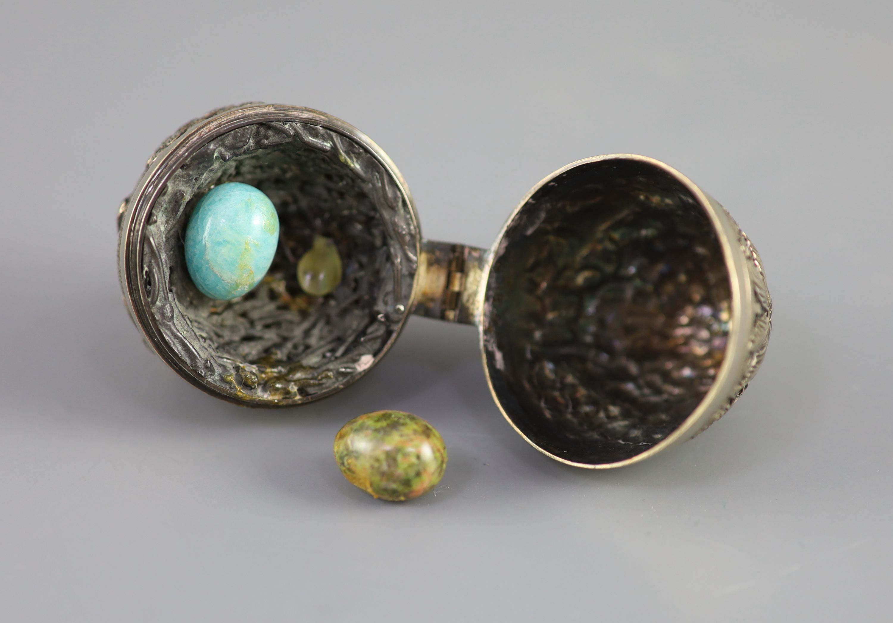 A graduated pair of Edwardian novelty silver gilt condiments, modelled as eggs, with bird's nest interior including two 'marbled' eggs